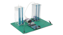 Angled view of the capacitive touch liquid level indicator reference design with two transparent tanks, connecting tubes, sensors, and a CPU board and control board.