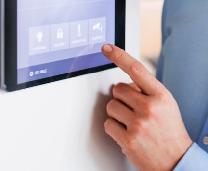 Person pointing to a tablet display with smart home screen