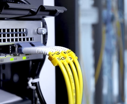 Fiber optic cable and high speed network router switch in a technology data center room.