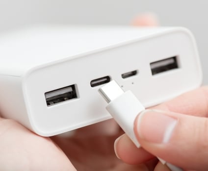 Hand plugging a usb type-c cable into a powerbank