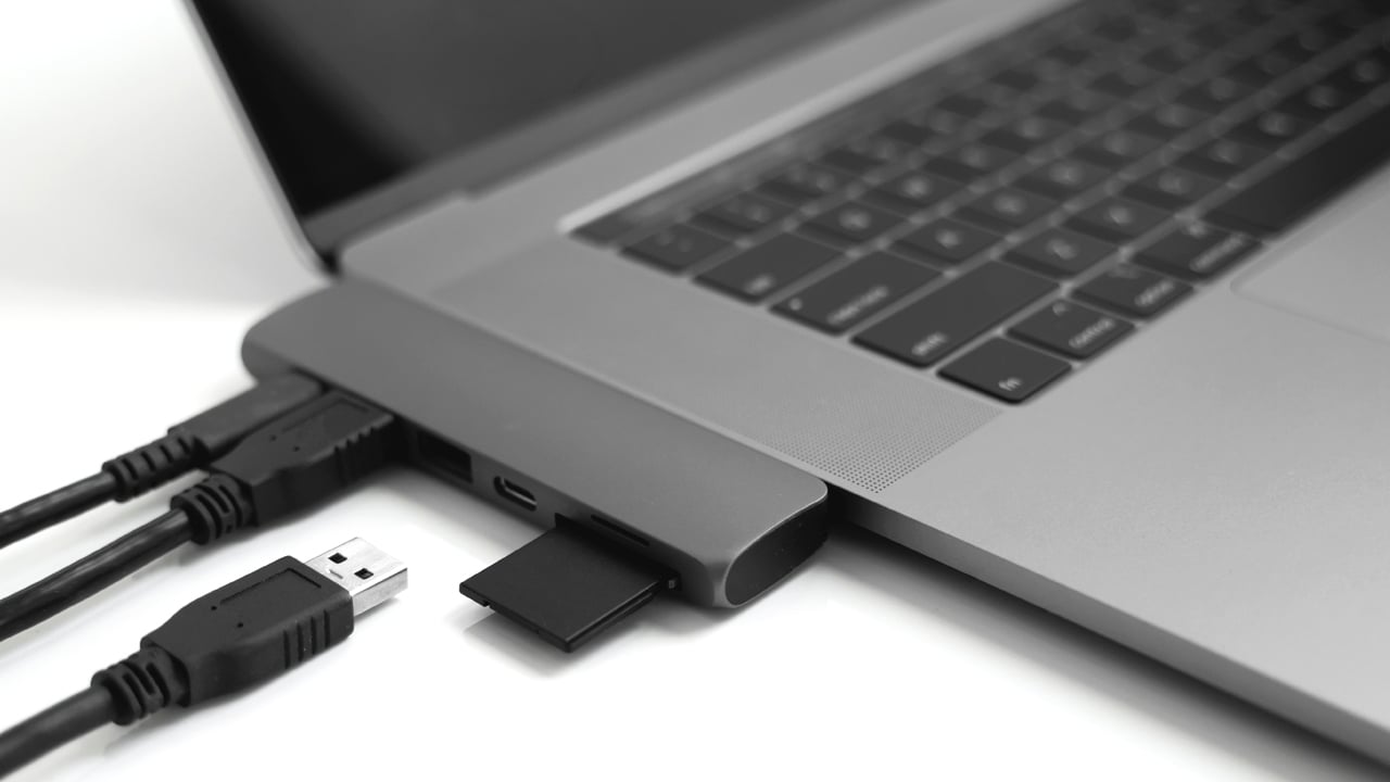 USB Type-C Adapter Laptop with USB Type-C adapter with plugged USB cables and SD card.
